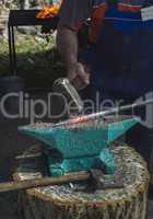 Blacksmith forges iron on anvil