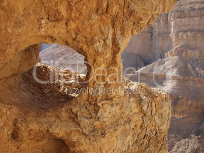 Window in the orange sandstone rock in stone desert, Israel