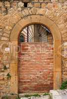 Old arched door blocked by brick wall