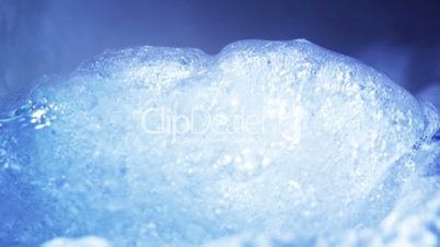 thawing ice in cyan light close-up timelapse