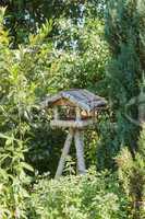 Vogelhaus aus Holz mit drei Beinen