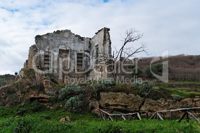 Farmhouse ruin among rural landscape