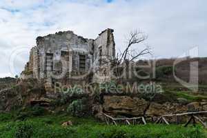 Farmhouse ruin among rural landscape