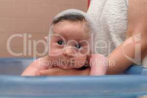 Cute baby in a bathtub with foam cap on his head