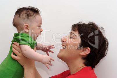 Cute baby held by his smiling mother profile view