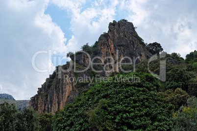 Black cliff towering above the forest