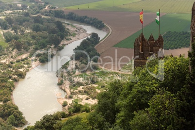 Almodovar Del Rio medieval castle with flags of Spain and Andalusia above Guadalquivir  river