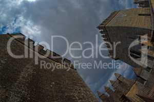 Fisheye view of towers of Almodovar del Rio medieval castle against the cloudy sky