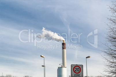 Schornstein Fabrik mit Rauch gegen den blauen Himmel