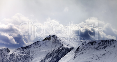 Mountains in evening cloudy sky