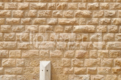 Texture of the wall built of rough yellow stone blocks