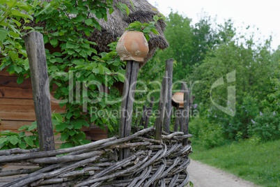 Lath fence around a farmer's house with clay pots on top of stakes in open air museum, Kiev, Ukraine