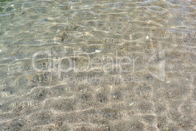 Texture of small pebbles of the sea bottom seen through the water