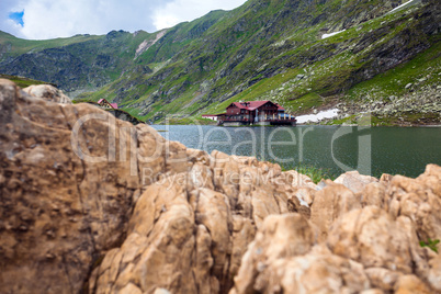 Idyllic view with cottege on Balea Lake shore in Fagaras Mountai