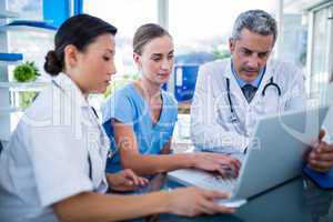 Doctors and nurse looking at laptop