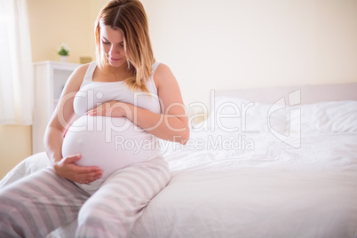 Pregnant woman looking at her belly