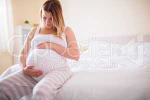 Pregnant woman looking at her belly