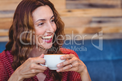 Casual brunette drinking coffee