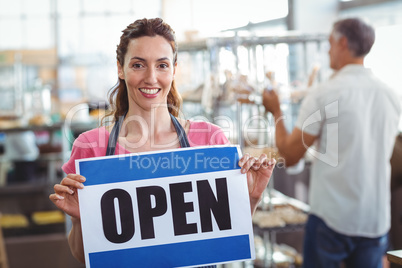 Pretty worker showing open sign