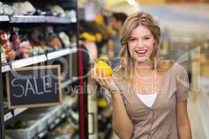 Portrait of a pretty smiling blonde woman buying vegetables