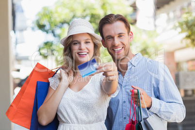 Cute couple showing a credit card