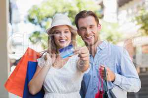 Cute couple showing a credit card
