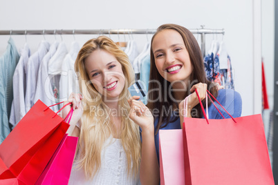 Happy friends holding a credit card