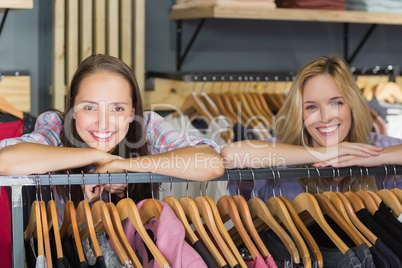 Two beautiful women with head on hand smiling at camera