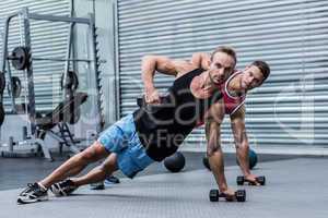 Muscular men doing a side plank