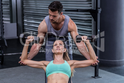 A muscular woman lifting dumbbells