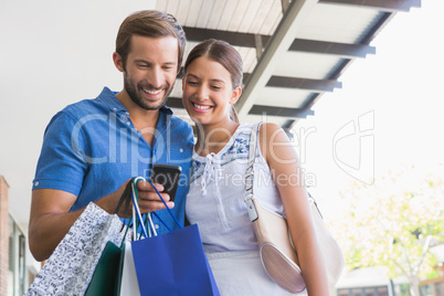 Young happy couple looking at mobile phone