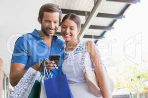 Young happy couple looking at mobile phone