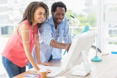 Two creative business colleagues discussing over a computer