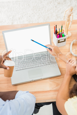 Colleagues using laptop and pointing the screen