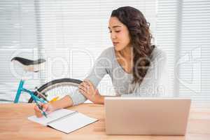 Young businesswoman writing on paper