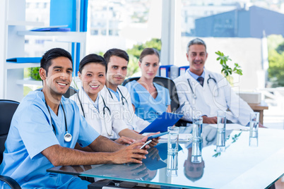 Happy doctors looking at camera while sitting at a table