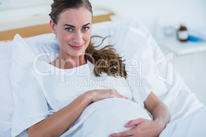 Happy pregnant woman smiling at camera