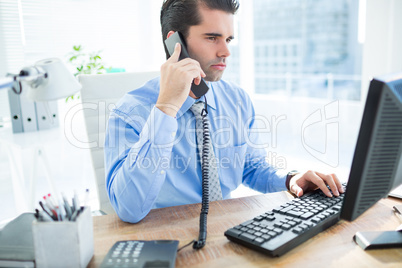 Businessman using computer and phoning Businessman using computer and phoning