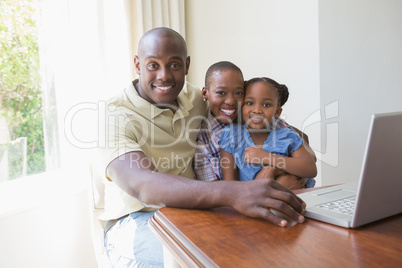 Happy smiling family using laptop