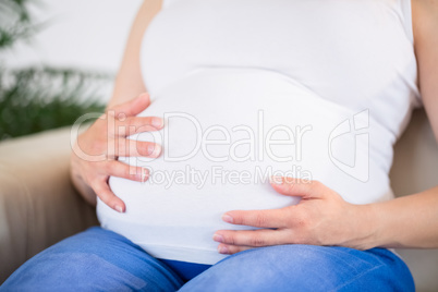 Close up of pregnant woman with hands on belly