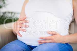 Close up of pregnant woman with hands on belly