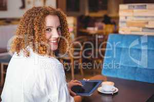 Pretty girl using a small tablet at table