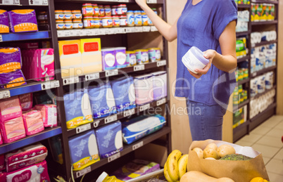 Casual woman taking product on shelf