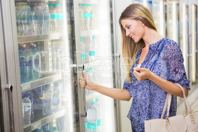 A pretty smiling blonde woman buying frozen products