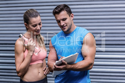 Muscular woman watching her results on clipboard