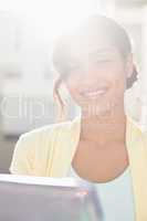 Casual businesswoman smiling at camera holding tablet pc