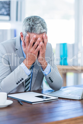 Depressed businessman with hands on head