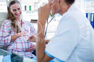 Happy pregnant woman being checked by doctor