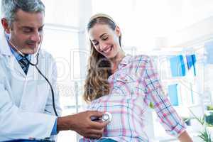 Doctor examining a pregnant woman with a stethoscope