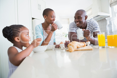 Happy family sitting and taking breakfast